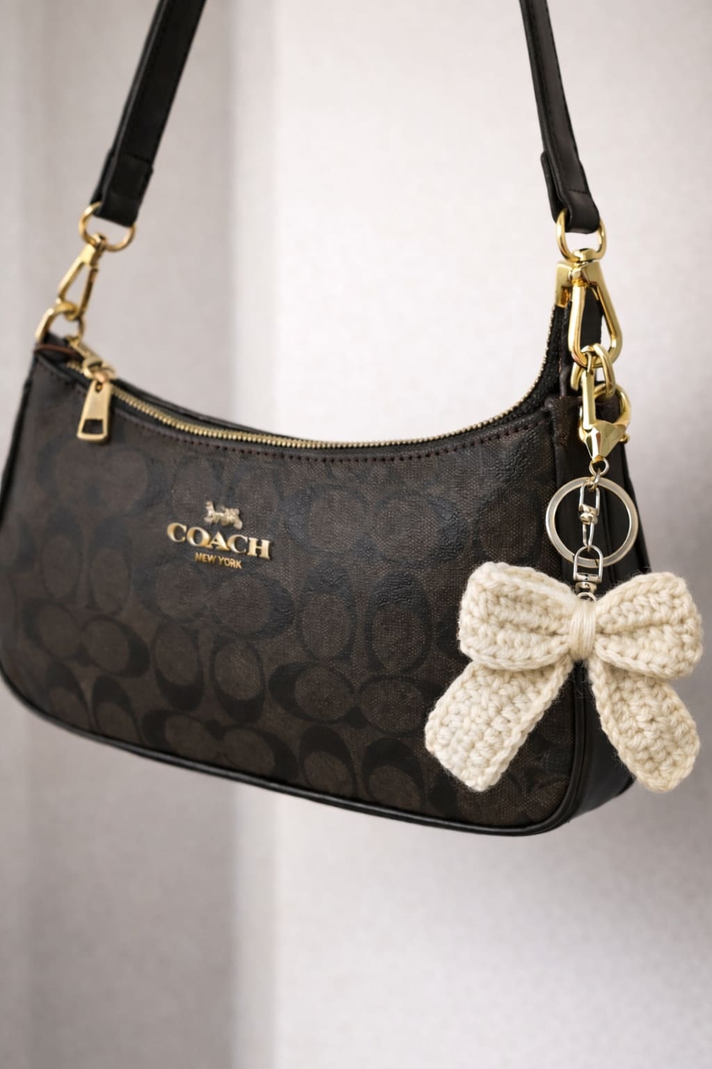 "Close-up of soft cream yarn texture on crochet bow bag charm