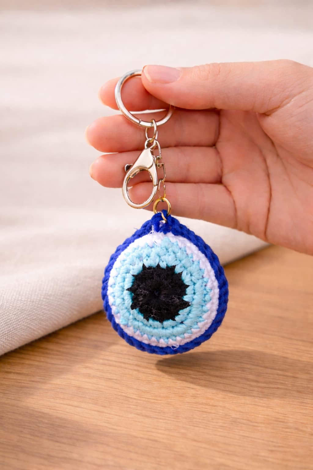 Evil eye crochet charm and keychain in hand