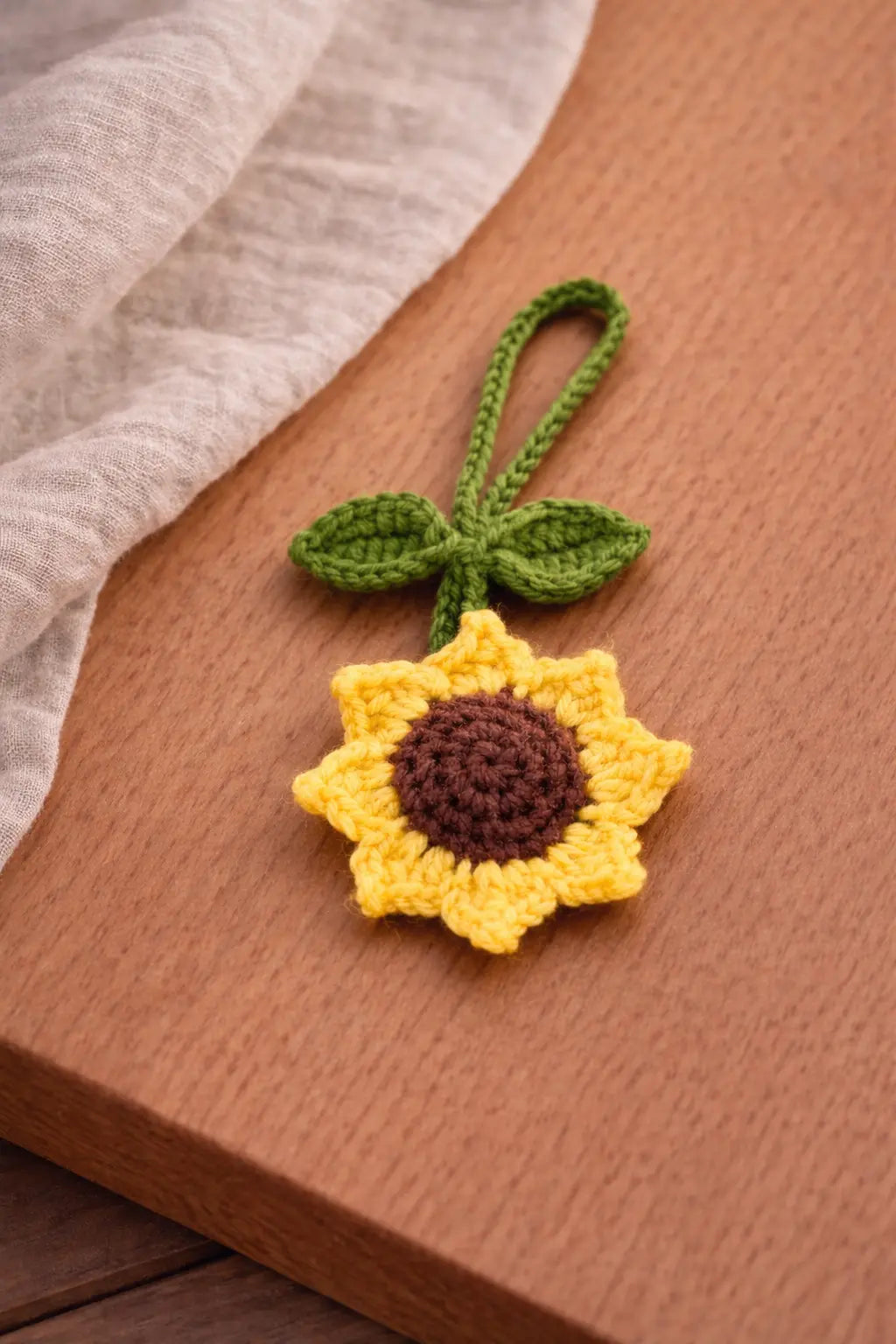 Close-up of the textured brown center and yellow petals on the crochet sunflower key charm