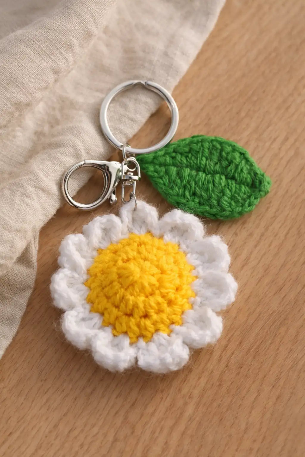 Handmade crochet white daisy keychain with yellow center and metal clasp